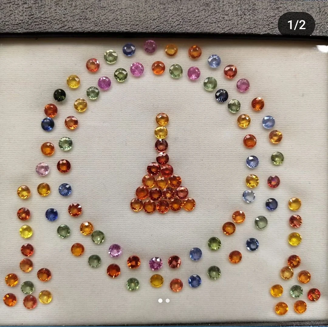 Coloured gemstones arranged on a light tray in a photo attached to Moksha Jain’s Google review