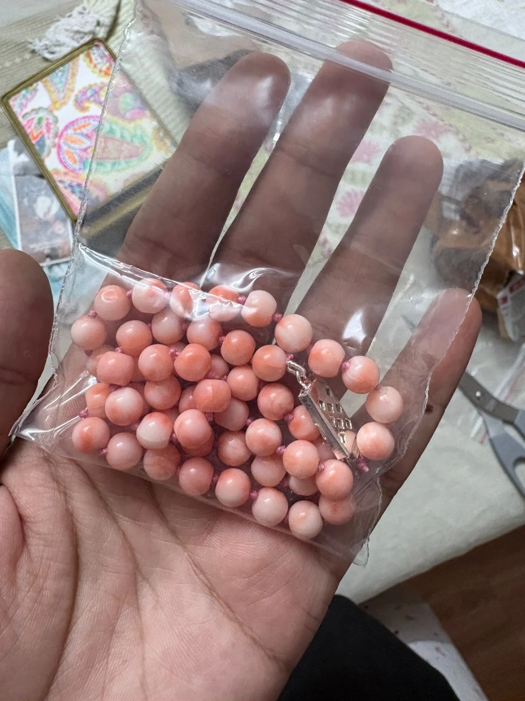 A hand holding a bag of pink beads in a photo attached to Tanuja Patil’s Google review